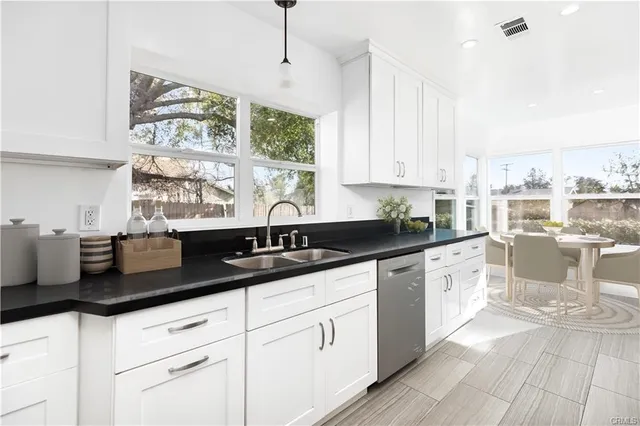 a kitchen with granite countertop white cabinets and white appliances