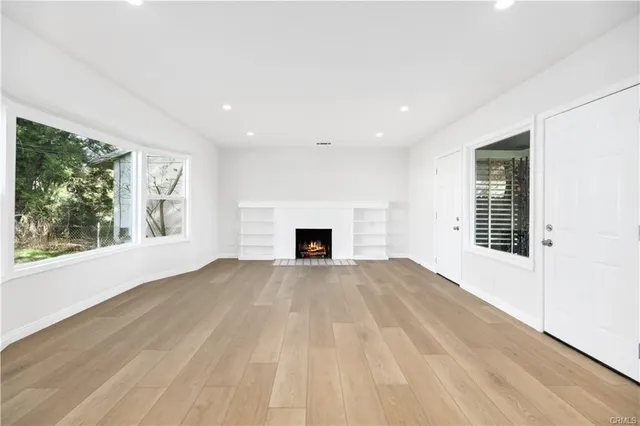 a view of an empty room with a window and fireplace