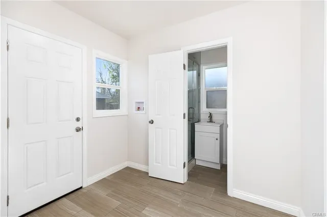 an empty room with wooden floor and windows