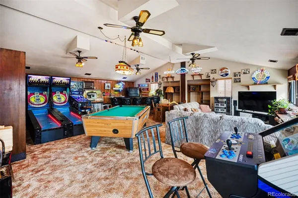 a living room with furniture pool table and window