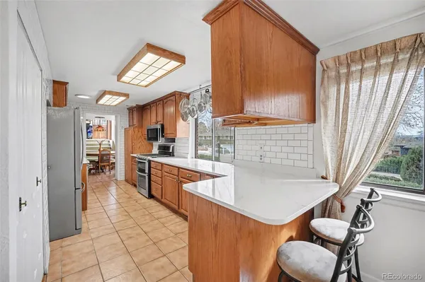 a kitchen with stainless steel appliances granite countertop a refrigerator and a sink