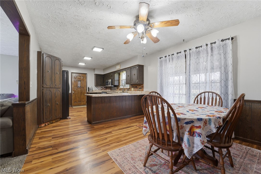 14557 Ellsworth Road Berlin Center, OH 44401 - Photo 8 of 23 Dining room featuring ceiling fan, a textured ceiling, and light wood-type flooring