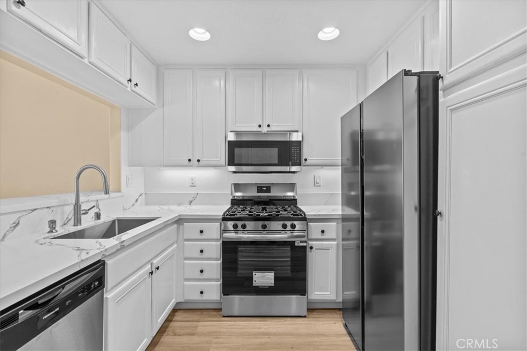19 Softwind Aliso Viejo, CA 92656 - Photo 8 of 28 a kitchen with stainless steel appliances a stove a sink and a refrigerator