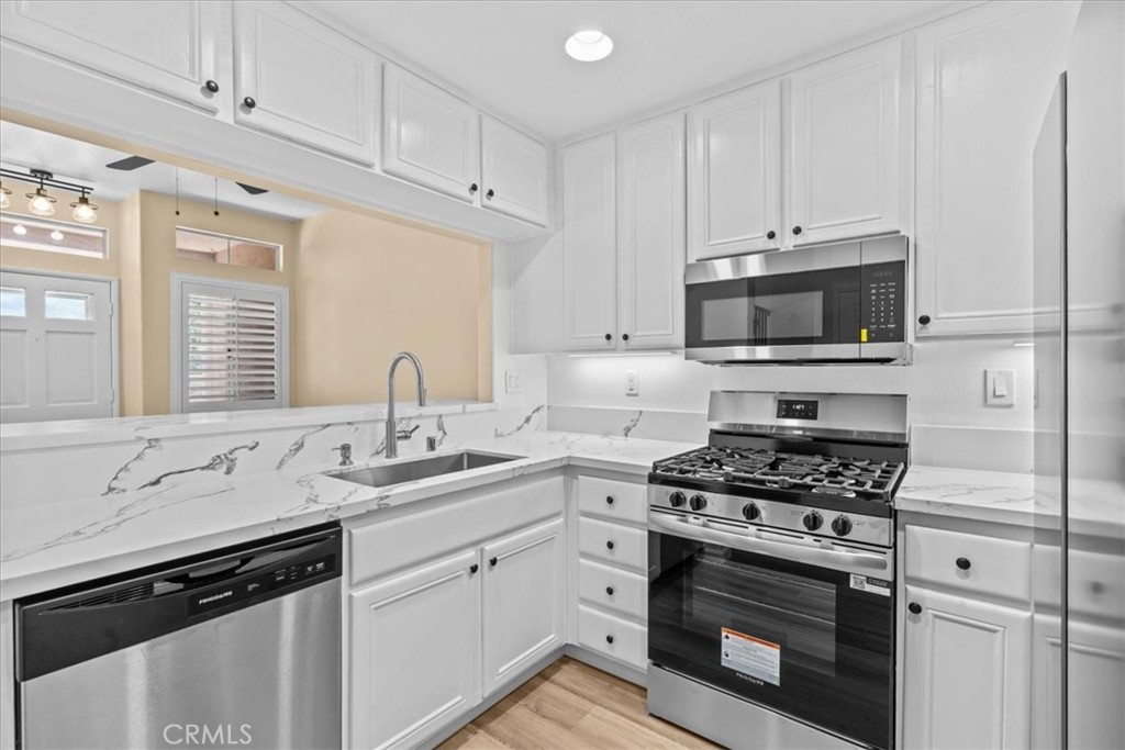 19 Softwind Aliso Viejo, CA 92656 - Photo 9 of 28 a kitchen with cabinets appliances a sink and a window