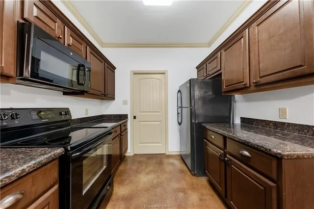 a kitchen with stainless steel appliances granite countertop a stove microwave and refrigerator