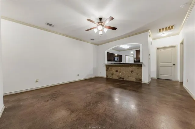 an empty room with fan and entrance