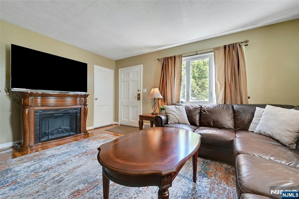 85 Edison Street Clifton, NJ 07013 - Photo 6 of 28 a living room with furniture a flat screen tv and a fireplace