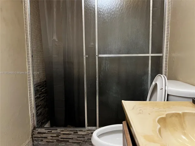 a bathroom with a sink toilet and shower