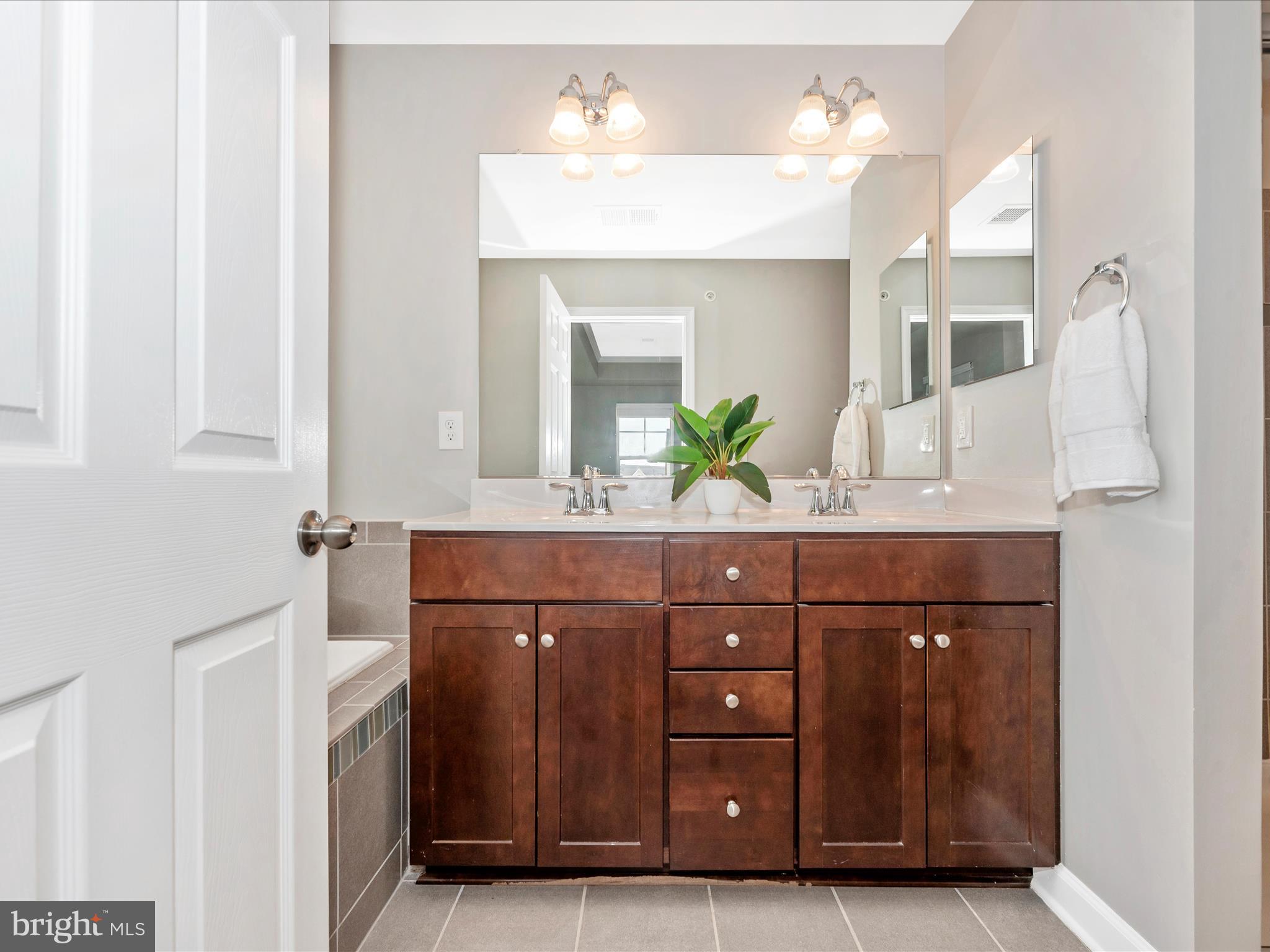 5920 Forum Square Frederick, MD 21703 - Photo 24 of 56 a bathroom with a granite countertop sink a mirror and a shower