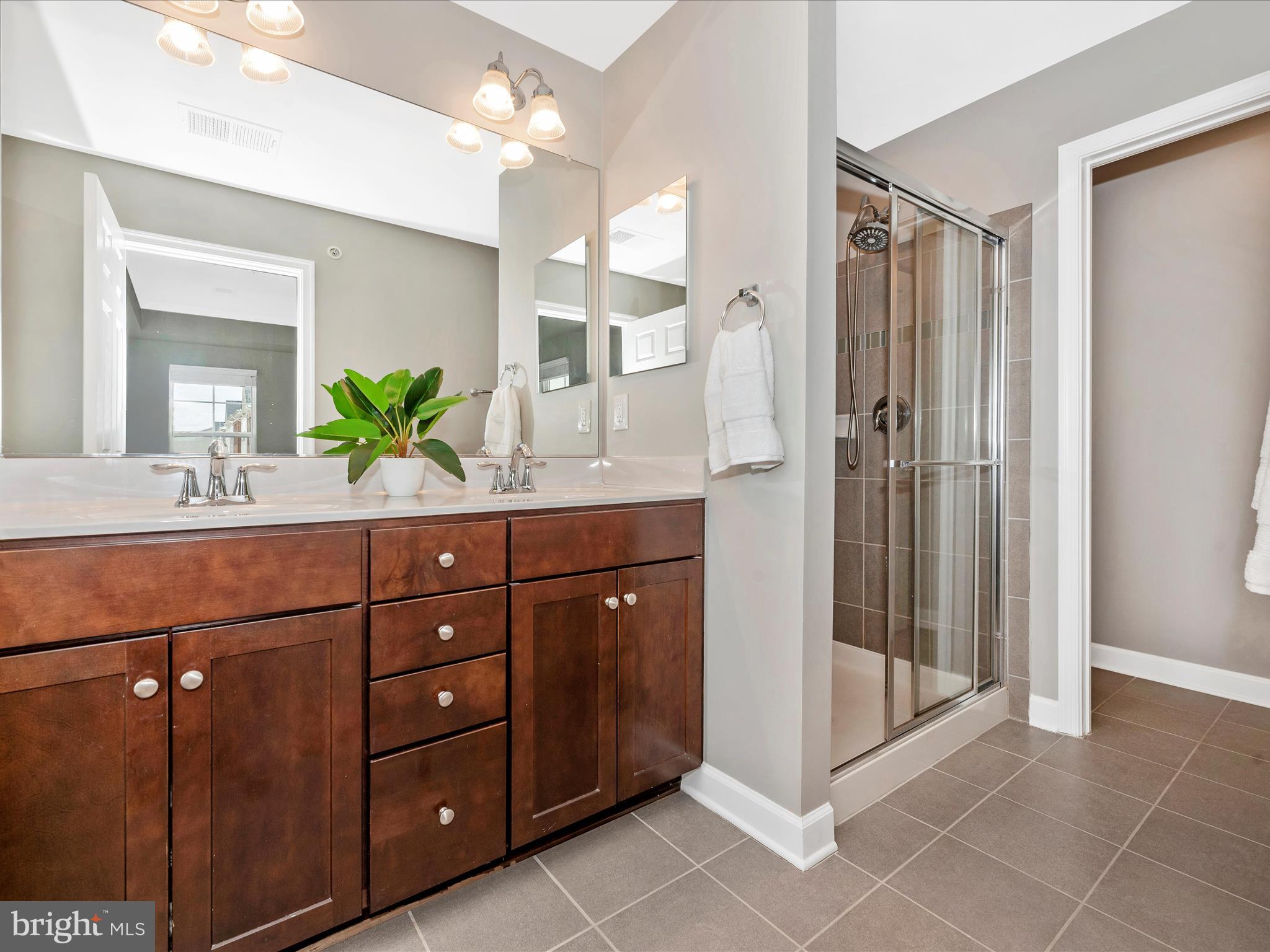 5920 Forum Square Frederick, MD 21703 - Photo 25 of 56 a bathroom with a granite countertop sink a mirror and a shower
