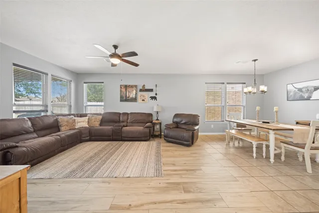 a living room with furniture kitchen view and a large window