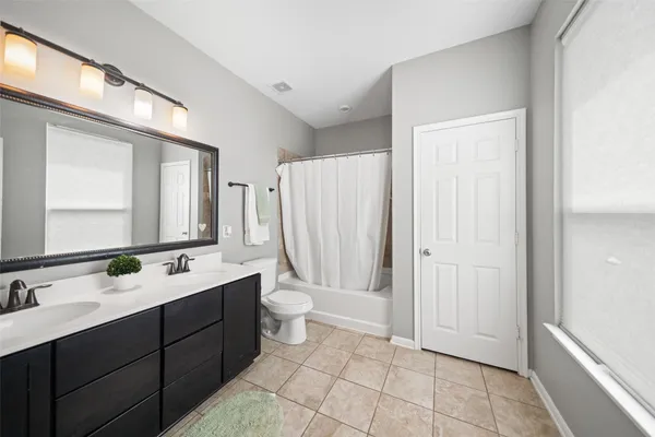 a bathroom with a double vanity sink mirror and toilet