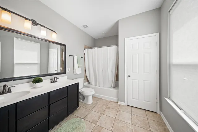 a bathroom with a double vanity sink mirror and toilet