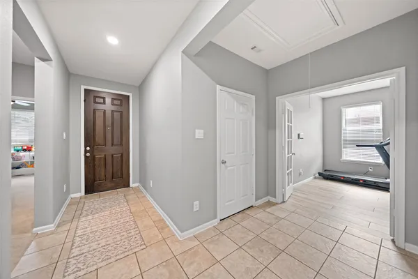 a view of a hallway with wooden floor and a bathroom