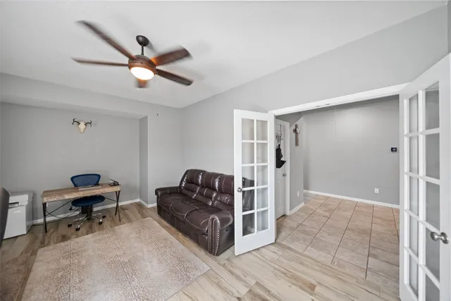 a living room with couches and a ceiling fan