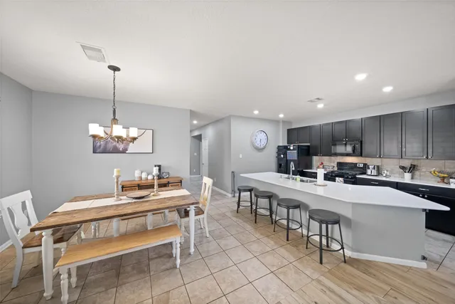 a kitchen with a dining table chairs and white cabinets