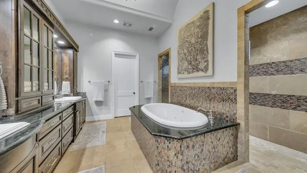 a large bathroom with a double vanity sink a mirror and a bathtub