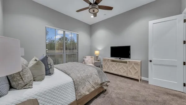 a living room with furniture a flat screen tv and a large window