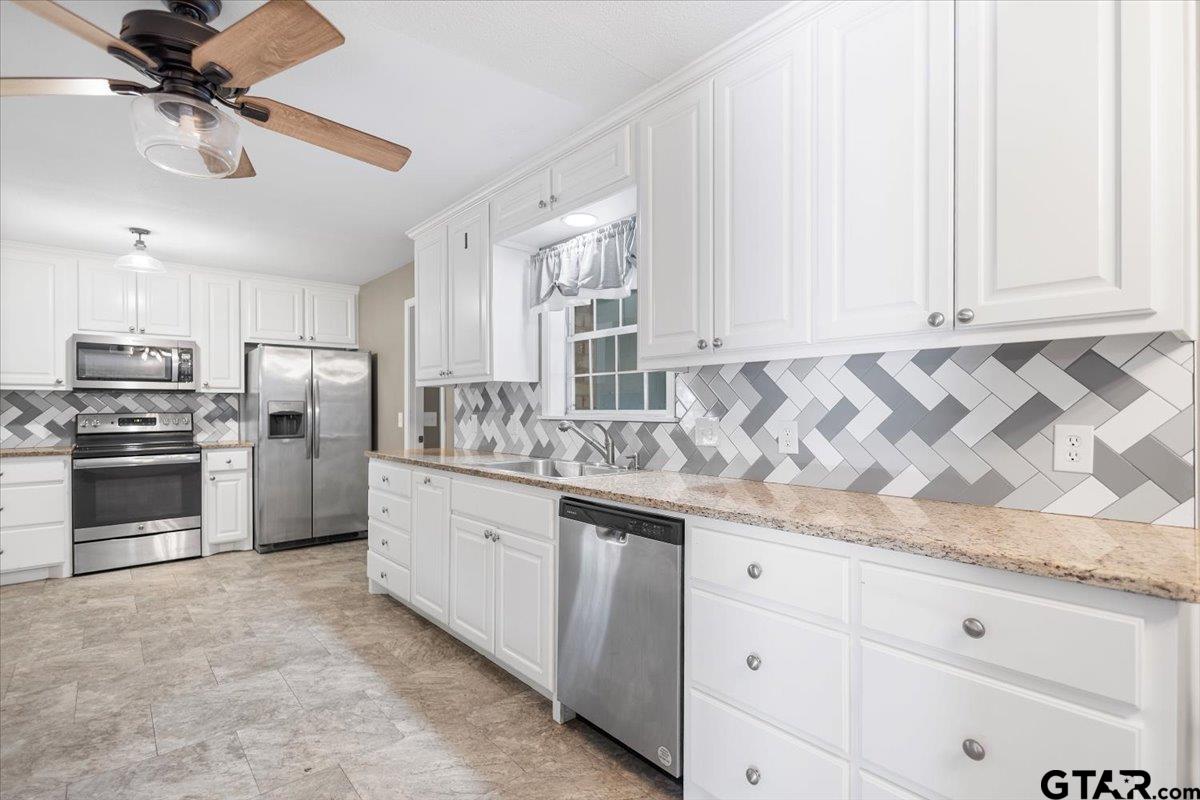 2005 Happy Street Mount Pleasant, TX 75455 - Photo 13 of 41 a kitchen with granite countertop white cabinets and stainless steel appliances