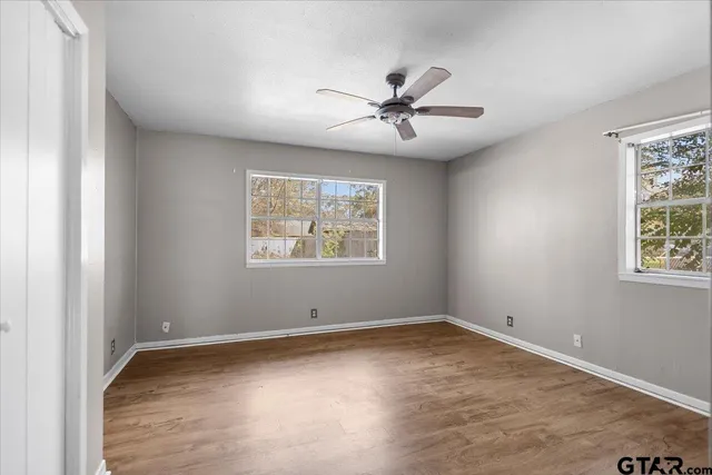 a view of a big room with wooden floor and windows