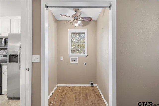 a view of an empty room with window and wooden floor