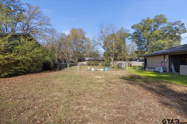 a view of a yard with wooden fence