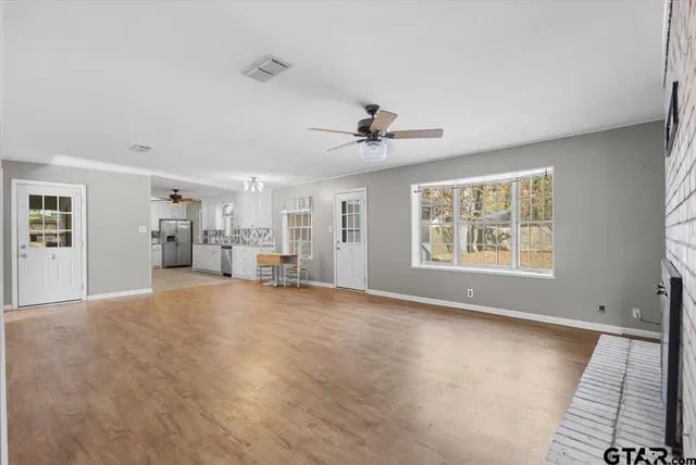 a view of empty room with wooden floor and window