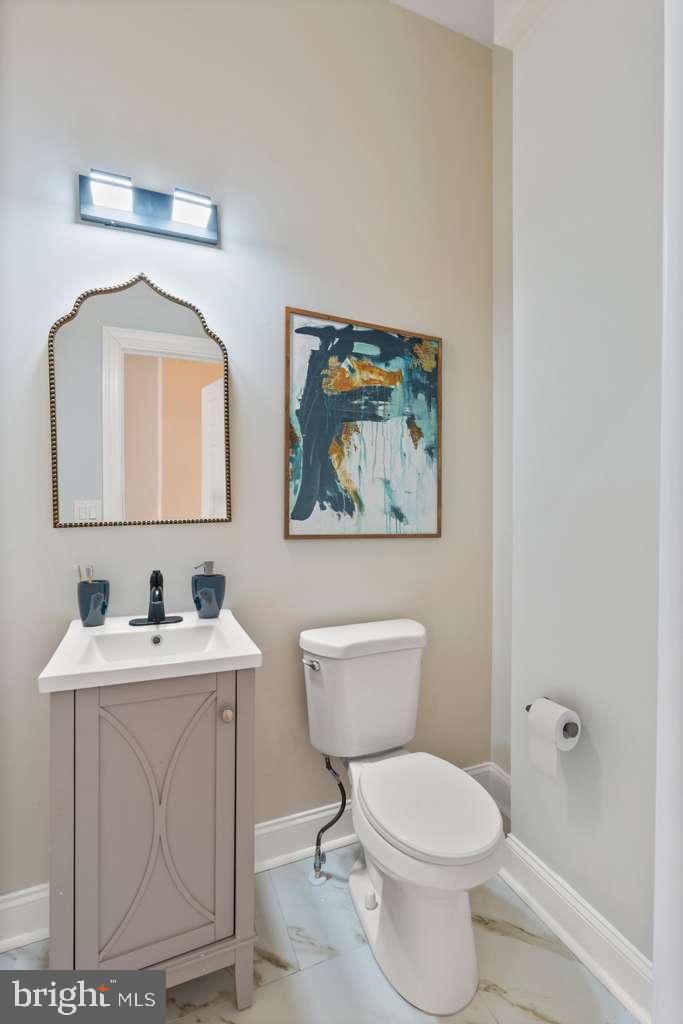 919 Stiles Street Baltimore, MD 21202 - Photo 15 of 36 a bathroom with a toilet a sink and mirror