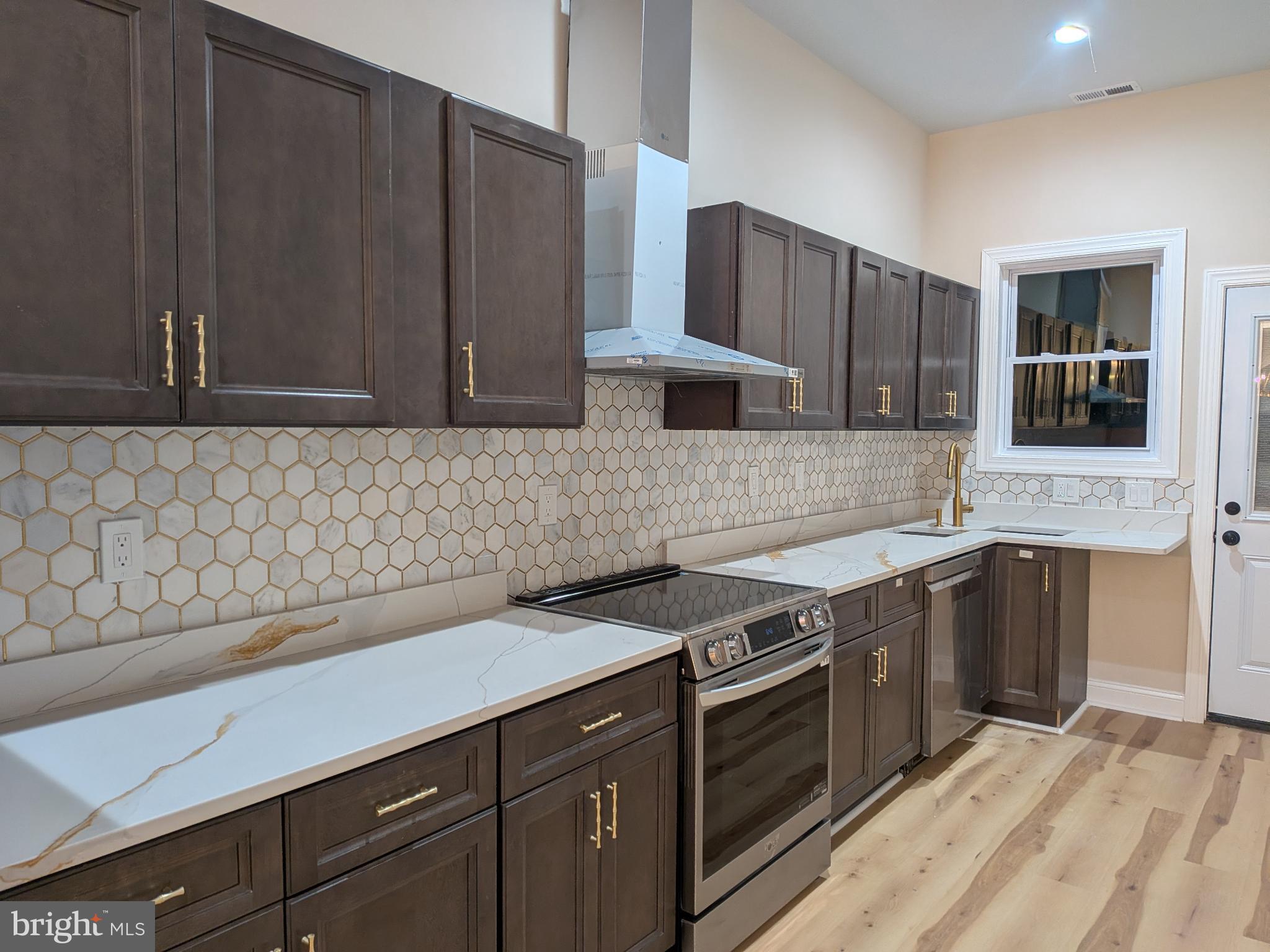 919 Stiles Street Baltimore, MD 21202 - Photo 29 of 36 a kitchen with stainless steel appliances granite countertop a sink stove and cabinets