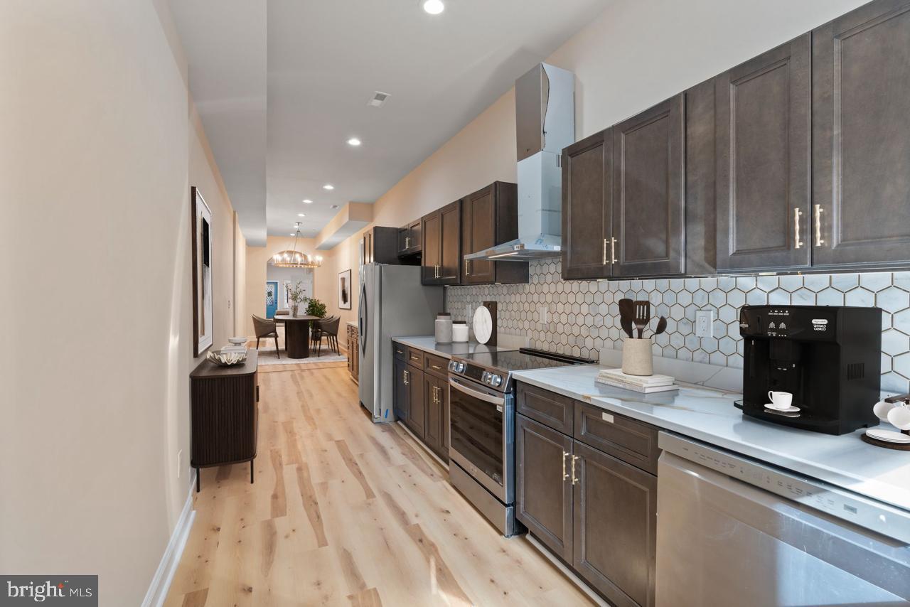 919 Stiles Street Baltimore, MD 21202 - Photo 9 of 36 a kitchen with stainless steel appliances granite countertop a sink stove and refrigerator