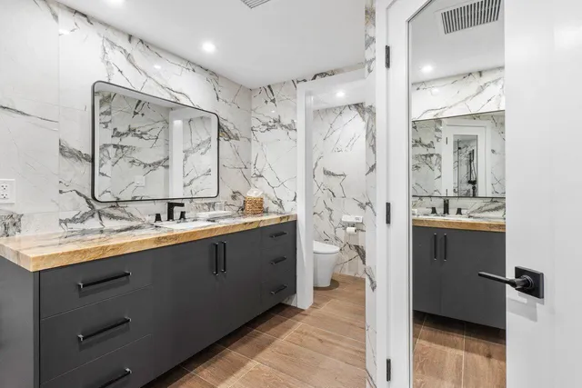 a bathroom with double vanity sink and mirror