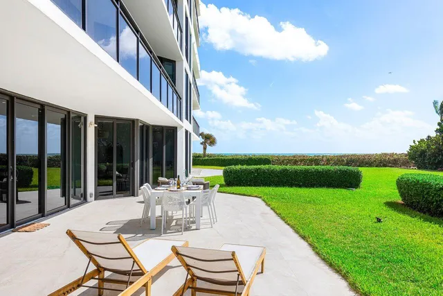 a view of a patio with a table chairs and backyard