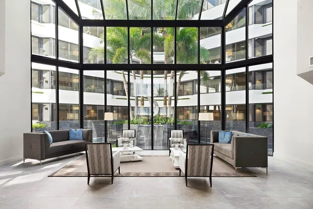 a living room with furniture and floor to ceiling windows