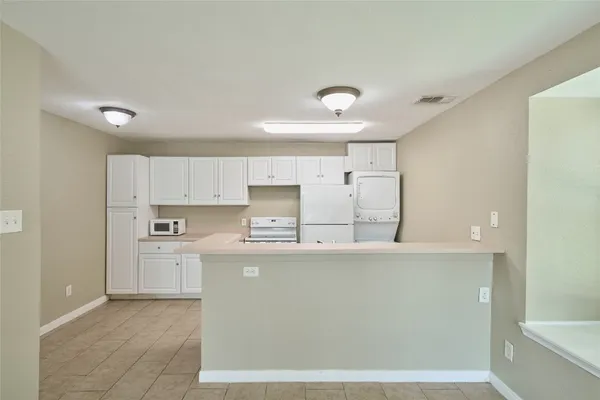 a kitchen with stainless steel appliances a refrigerator sink and white cabinets