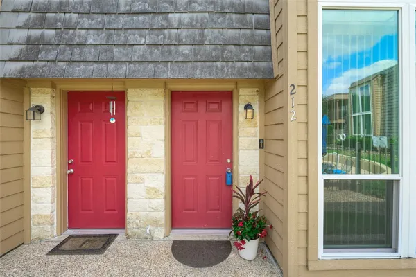 a front view of a house with a red door and door