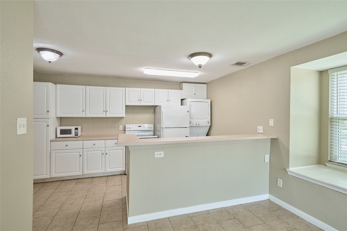 16120 Stuebner Airline Road, Unit 212 Spring, TX 77379 - Photo 10 of 29 a kitchen with cabinets and white appliances
