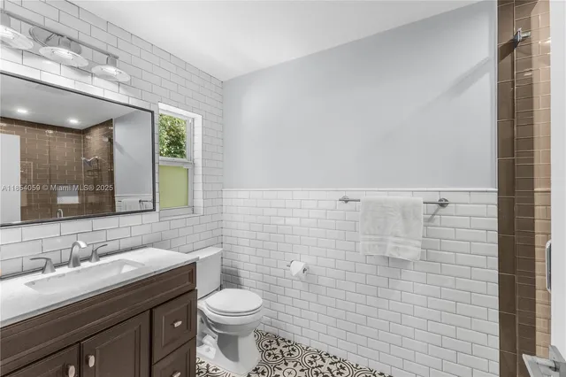 a bathroom with a sink a toilet and mirror