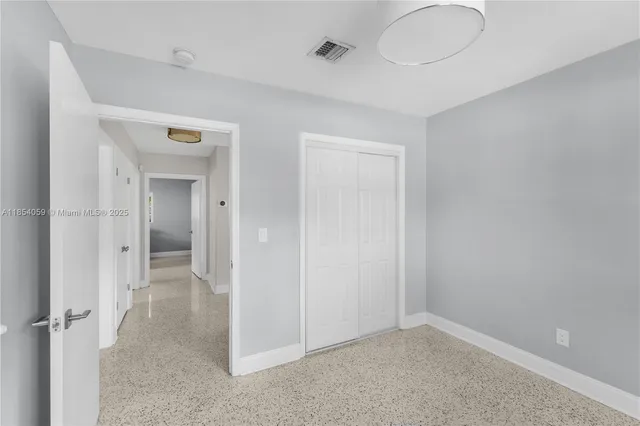 an empty room with windows and closet