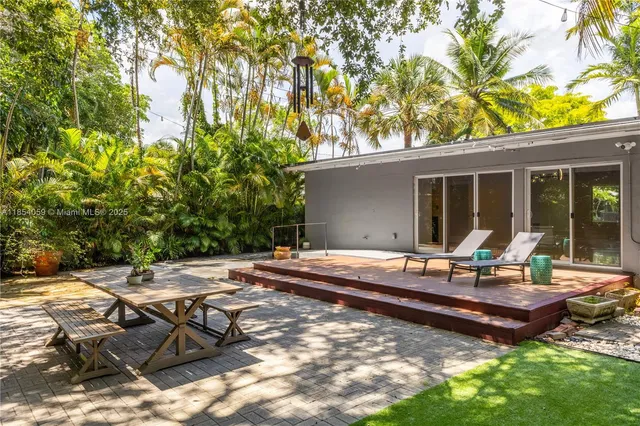 a backyard of a house with table and chairs