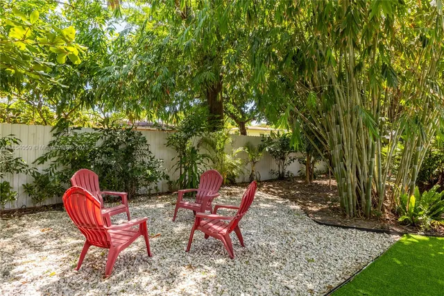 a view of house with backyard and sitting area