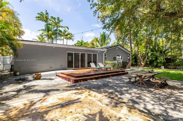 a view of a swimming pool with lawn chairs under an umbrella