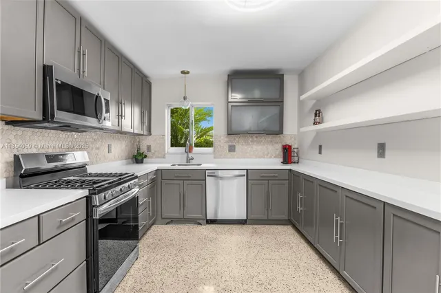 a kitchen with a sink stove and microwave