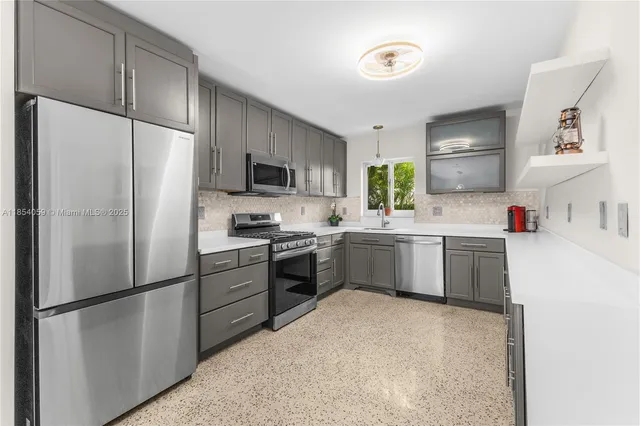 a kitchen with a refrigerator a sink stainless steel appliances and cabinets