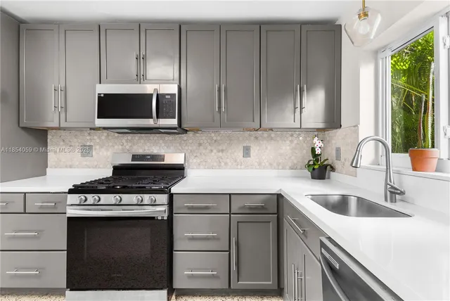 a kitchen with granite countertop a sink and a stove