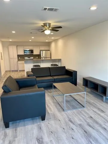 a living room with furniture and a ceiling fan