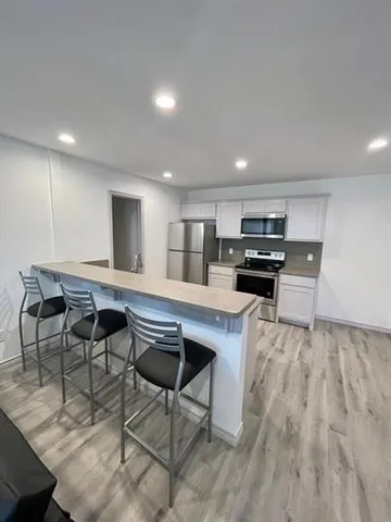 a kitchen with kitchen island a stove a table and chairs in it