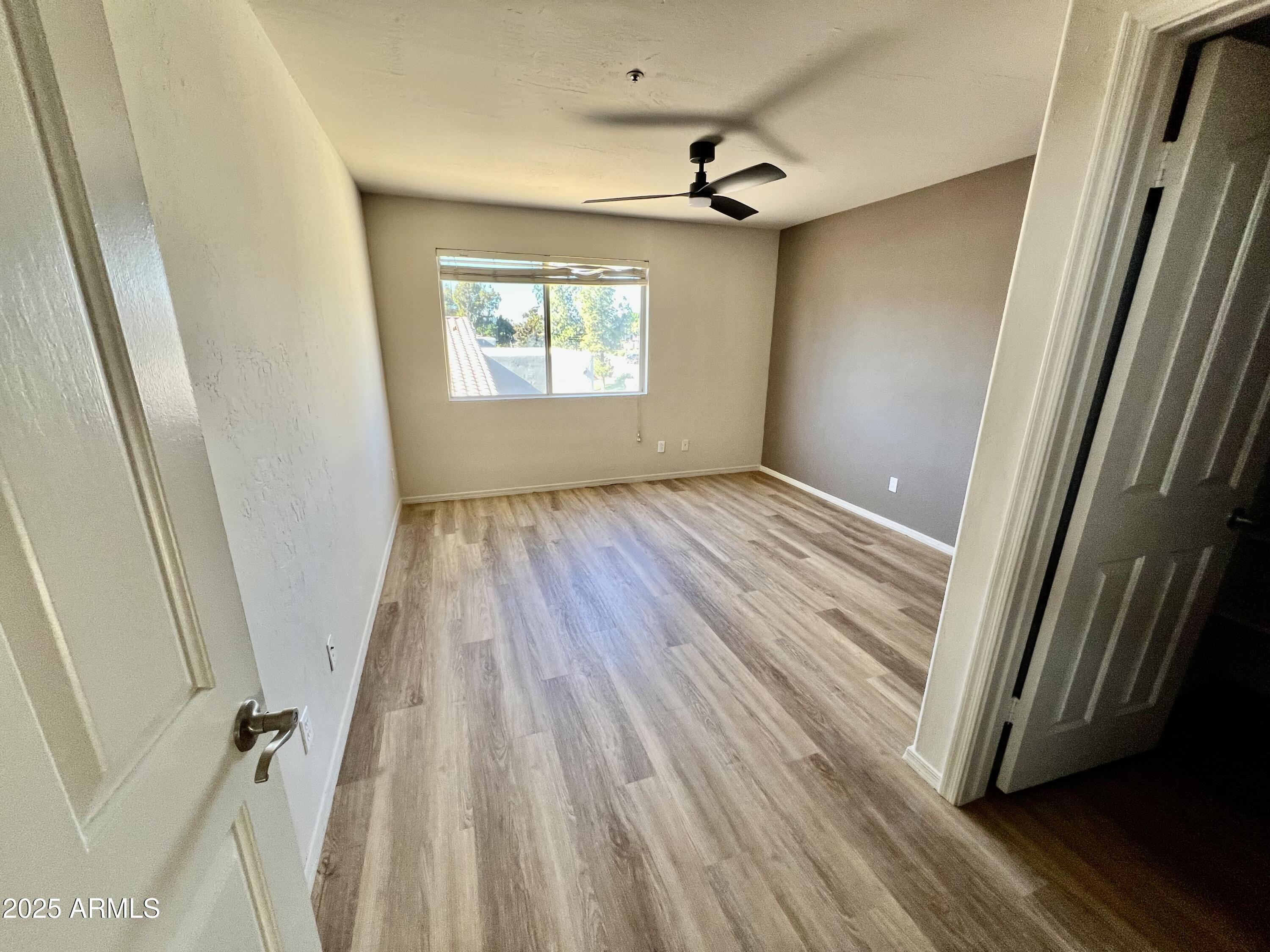 14145 North 92nd Street, Unit 2101 Scottsdale, AZ 85260 - Photo 13 of 30 a view of an empty room with wooden floor and a window