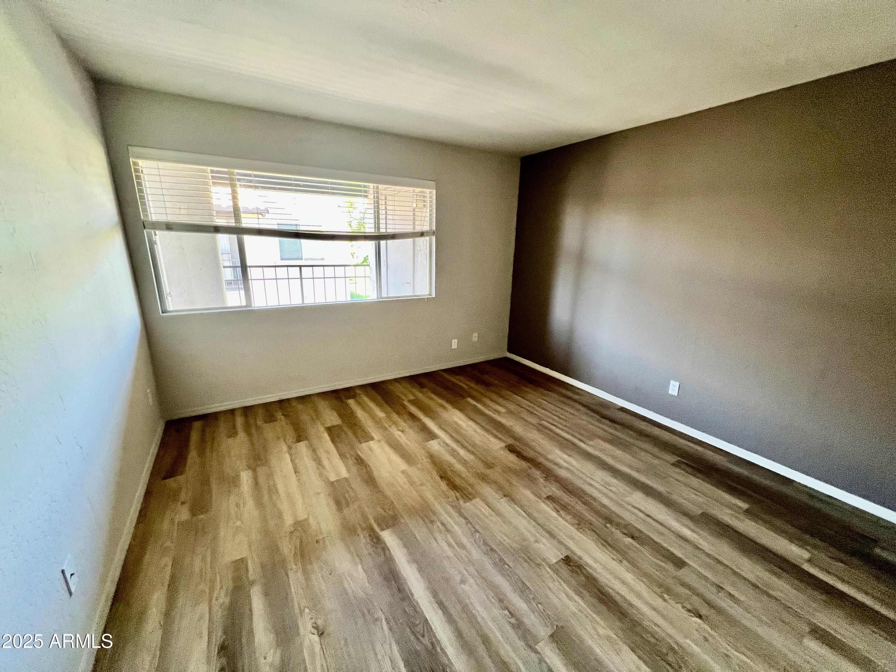 14145 North 92nd Street, Unit 2101 Scottsdale, AZ 85260 - Photo 16 of 30 a view of an empty room with wooden floor and a window