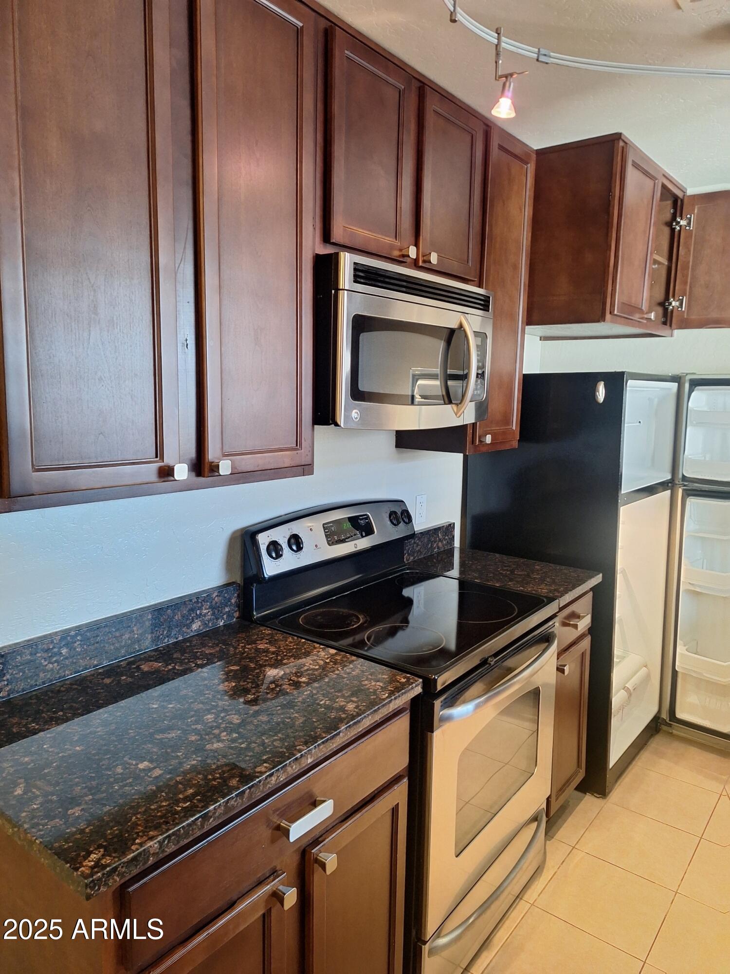 14145 North 92nd Street, Unit 2101 Scottsdale, AZ 85260 - Photo 20 of 30 a kitchen with stainless steel appliances granite countertop a sink a stove microwave and cabinets