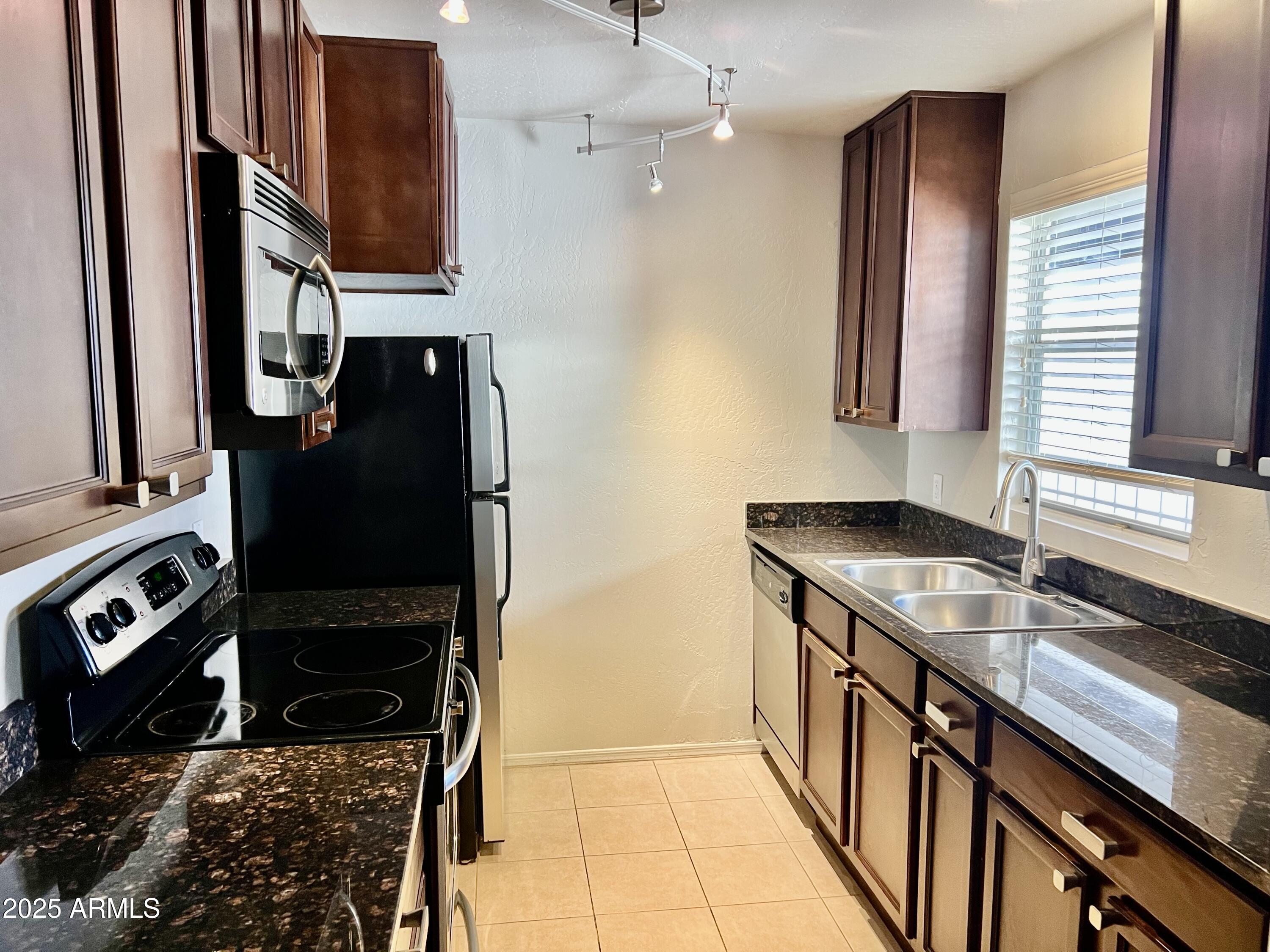 14145 North 92nd Street, Unit 2101 Scottsdale, AZ 85260 - Photo 7 of 30 a kitchen with stainless steel appliances granite countertop a sink stove and refrigerator
